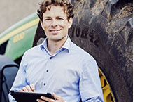 Gerald Hein, Leiter Landwirtschaft bei der DKB vor Traktor
