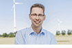 Jörg-Uwe Fischer, Leiter Erneuerbare Energien bei der DKB vor Windkraftanlage